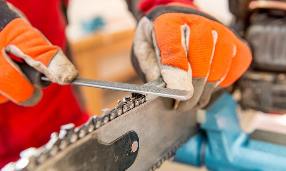 A file sharpening a chainsaw