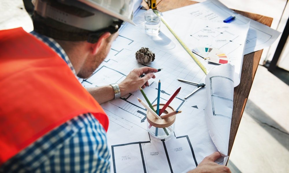 a man looking at building drawings