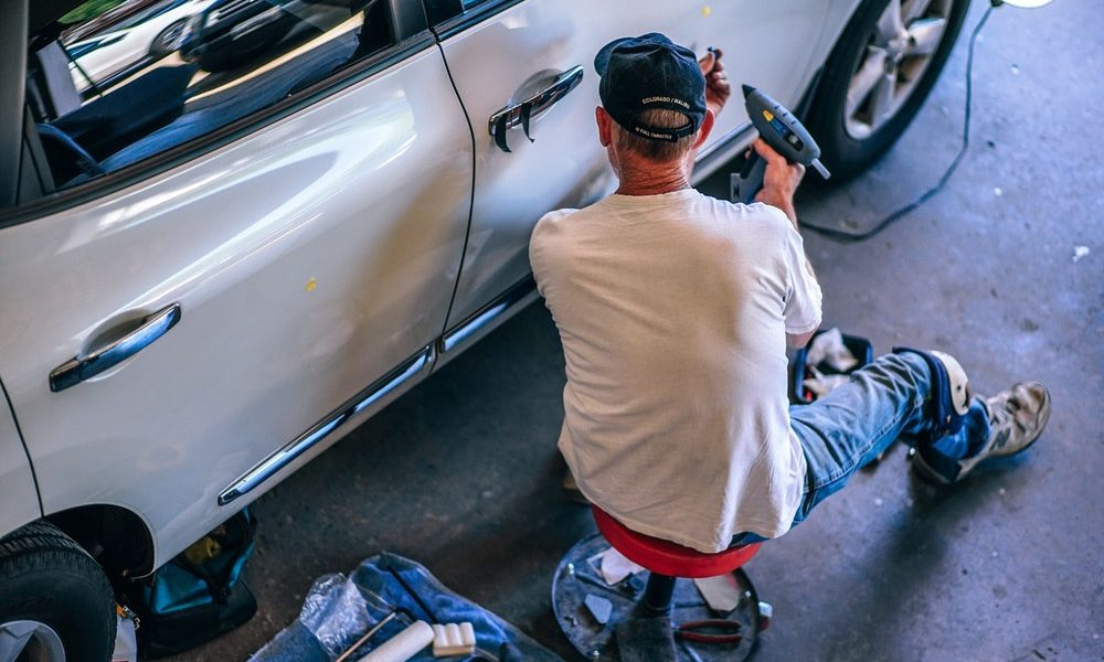 someone using a glue gun on a car 