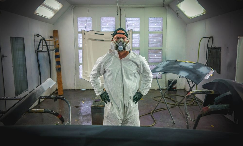 a man wearing paint suit in a paint shop