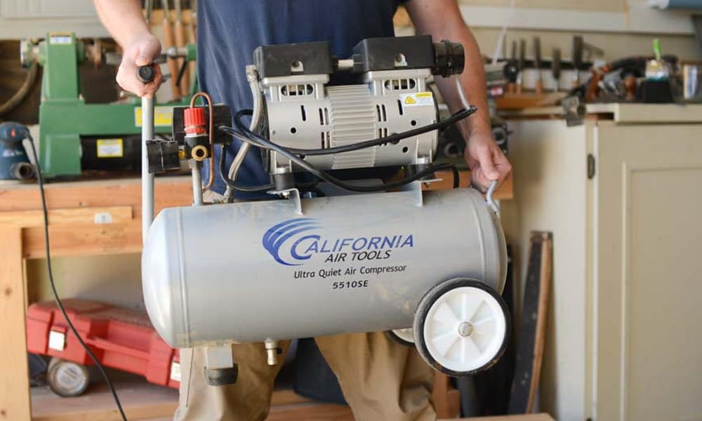 A man holding a air compressor