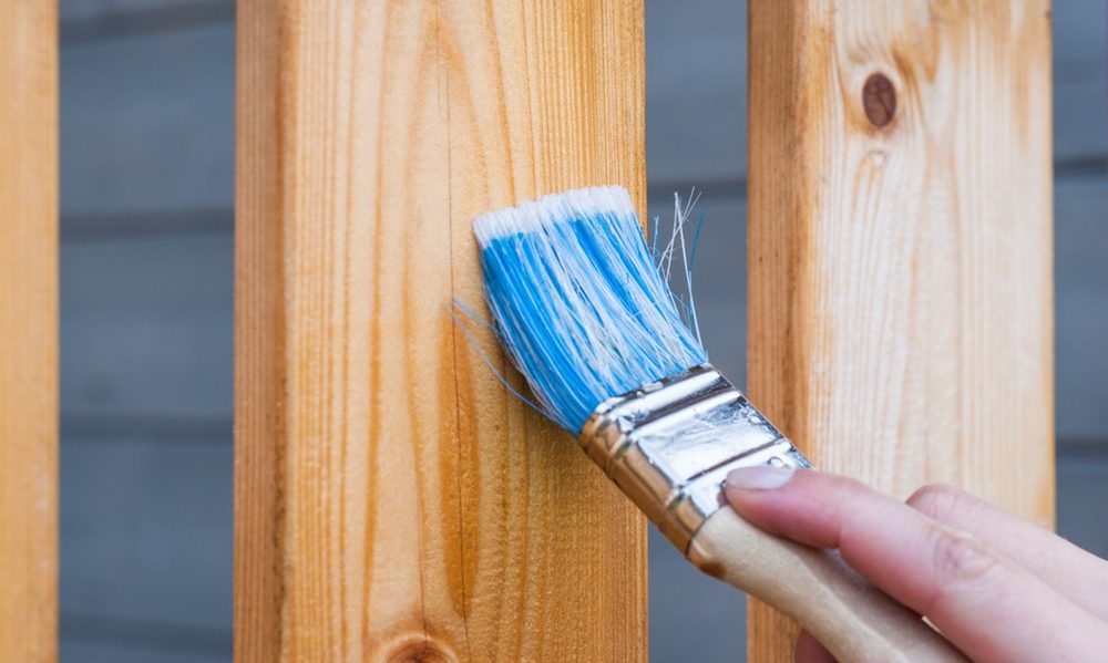 paint brush painting a wood panel