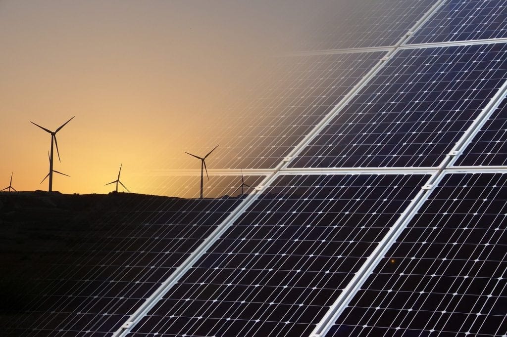 solar panel with wind turbines in the background