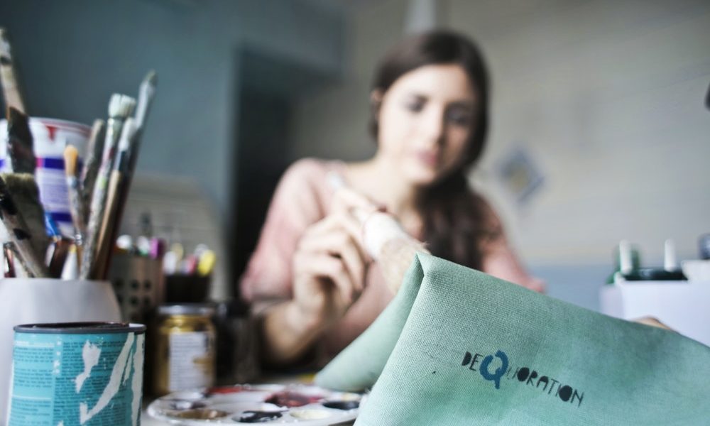 A woman painting on fabric