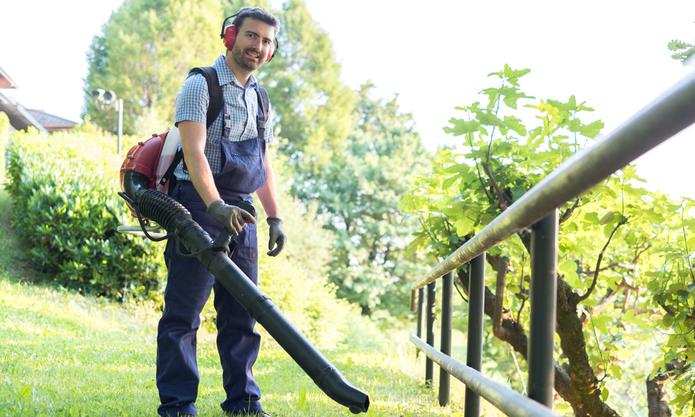 Man wearing a backpack leaf blower