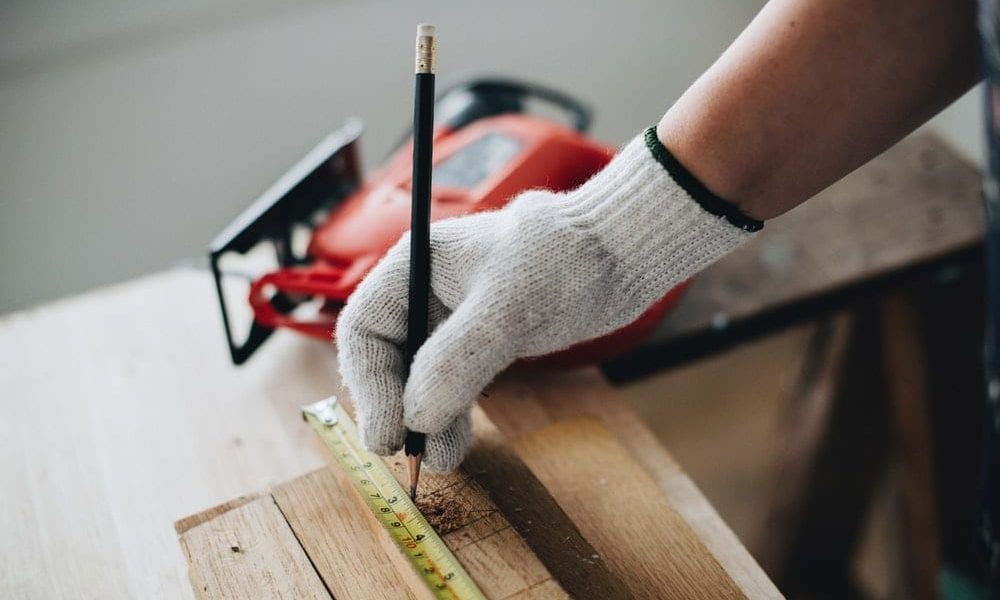 A person using a tape measure with a pencil