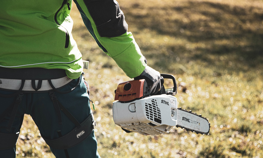 Man holding small chainsaw