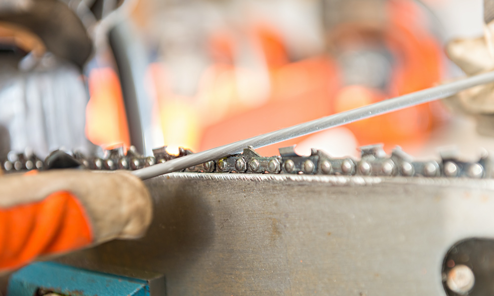 A file sharpening a chainsaw chain