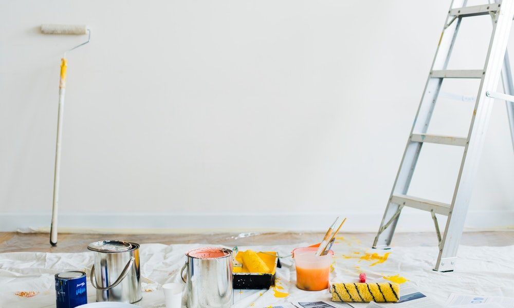 step ladder with paint tools and paint tins on the floor