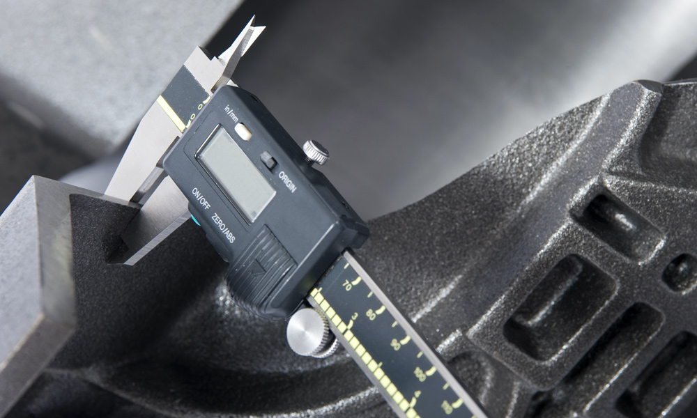 a digital Caliper measuring a piece of metal