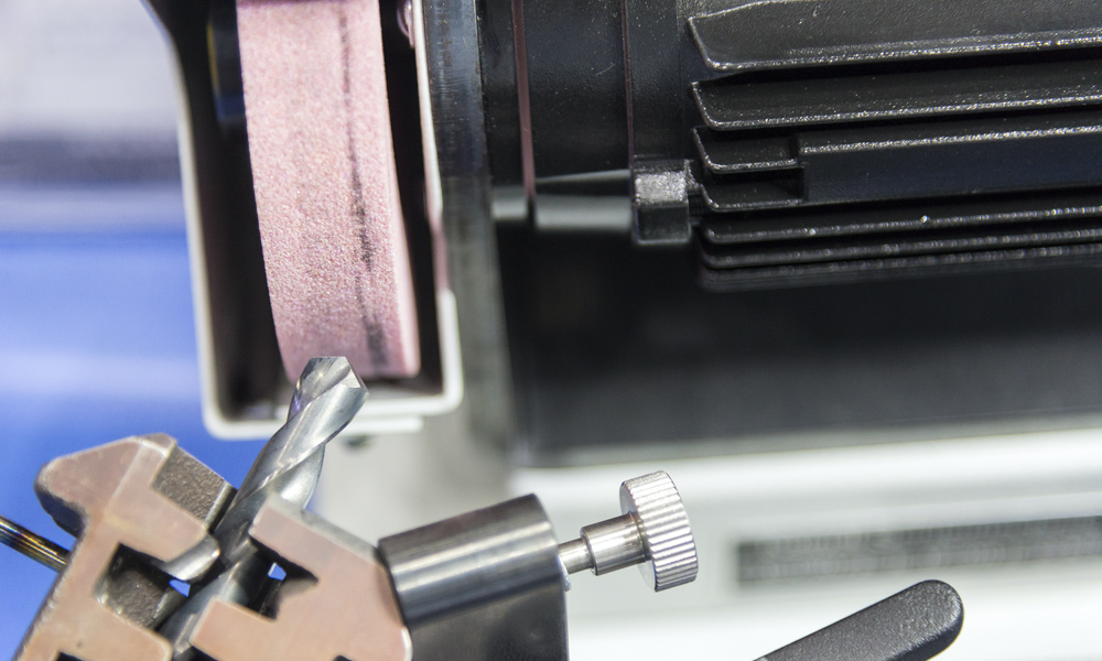 A close up of a drill bit being sharpening