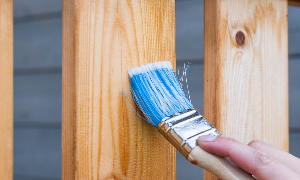 paint brush painting wood fence