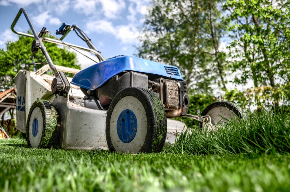 lawn mower sitting on half cut grass