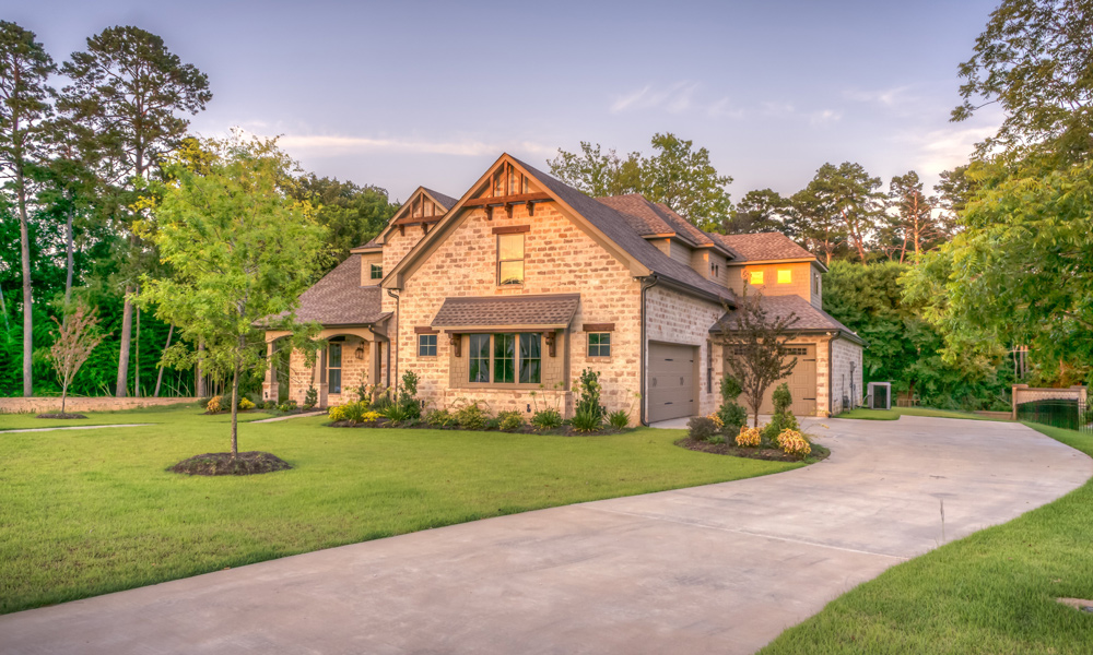 a house with a long driveway with grass either side