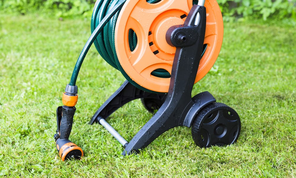 hose reel on wheels sitting on green grass