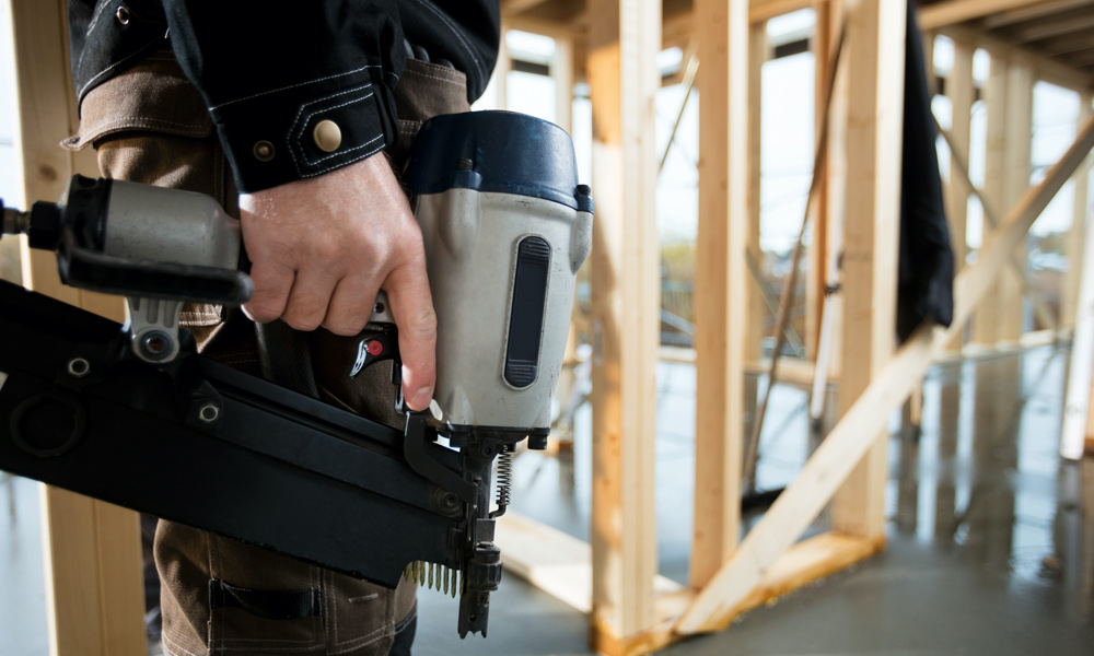 work person holding a nail gun