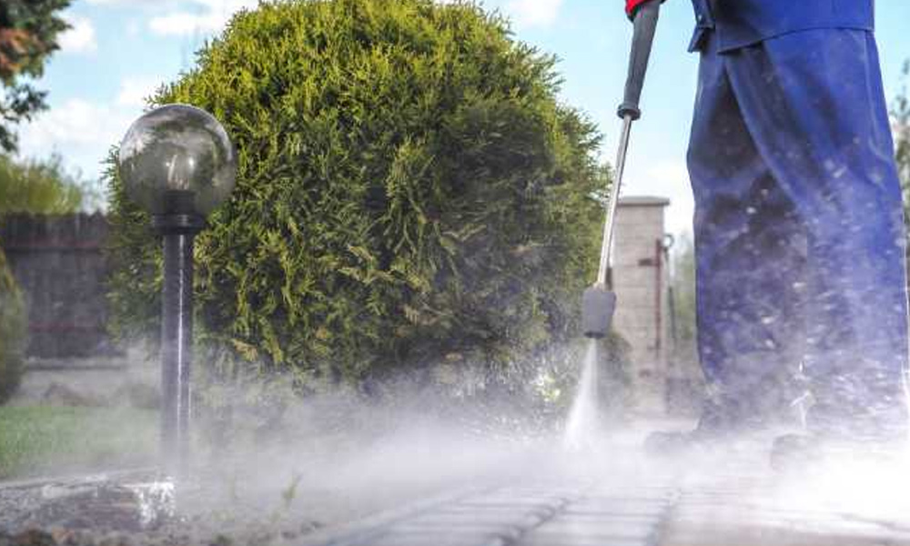 a man jet washing a pathway