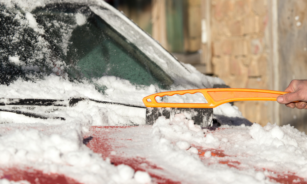 snow brush clearing snow of a car