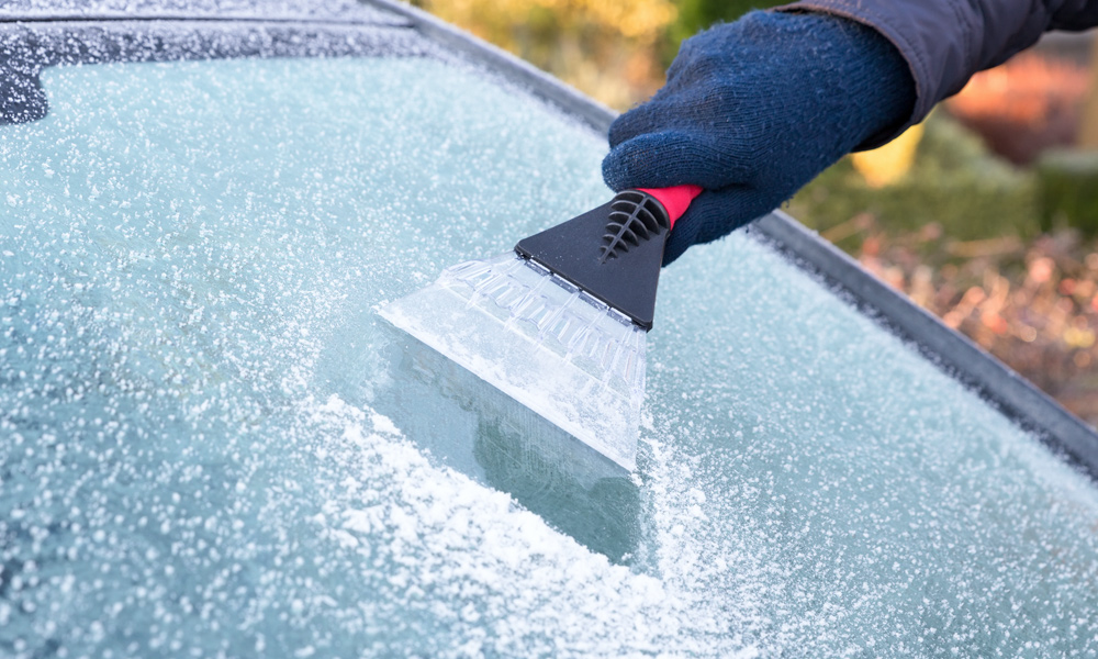 someone scapering ice of a car windscreen