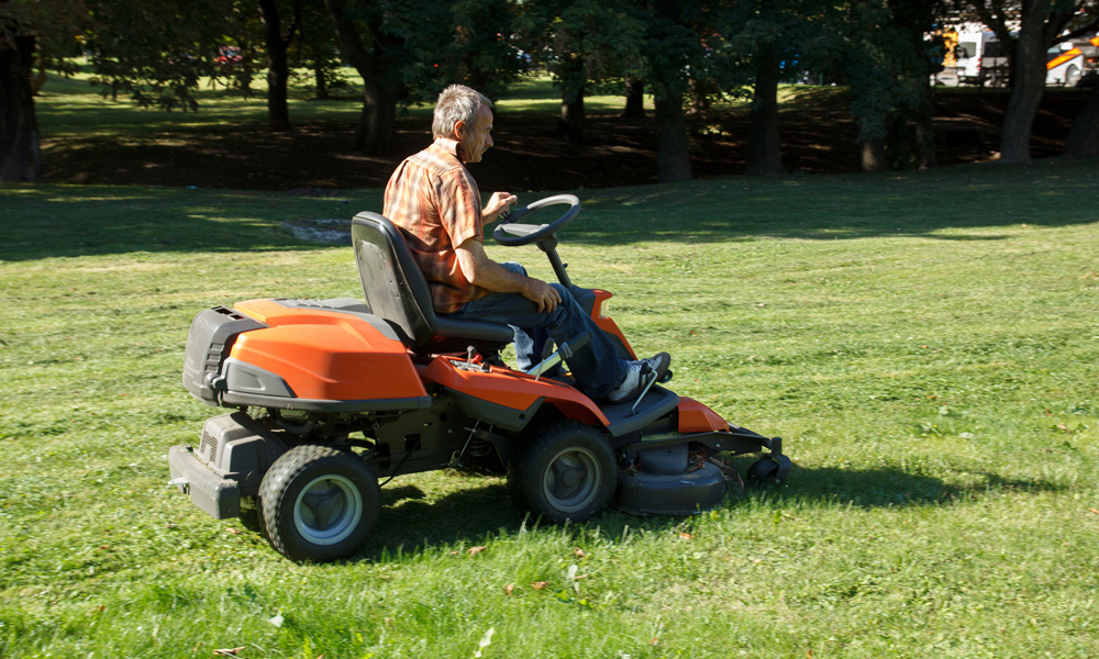 a man using a zero turn mower