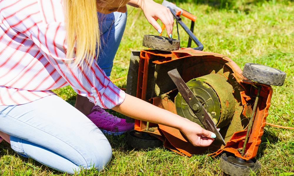 a women changing a lawn mower blade