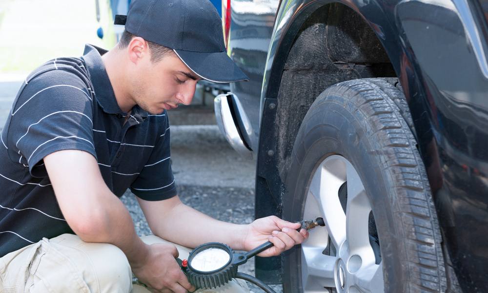 a man using a tire pressure gauge 