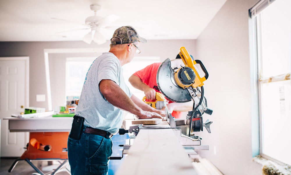 two workman using a sliding miter saw