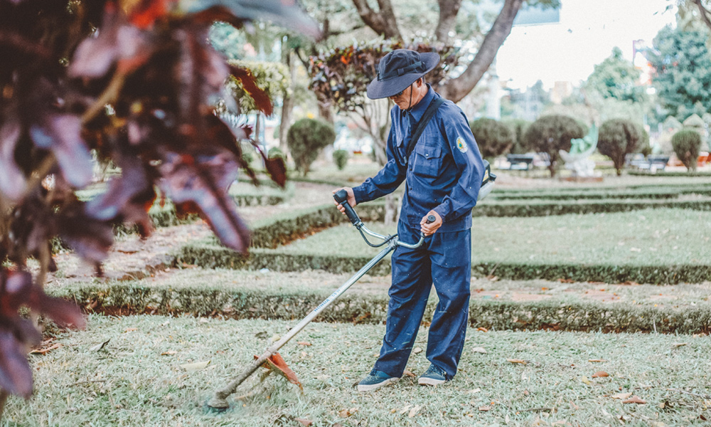 A workman holding a string trimmer