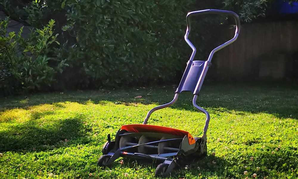 A reel lawn mower sitting on grass