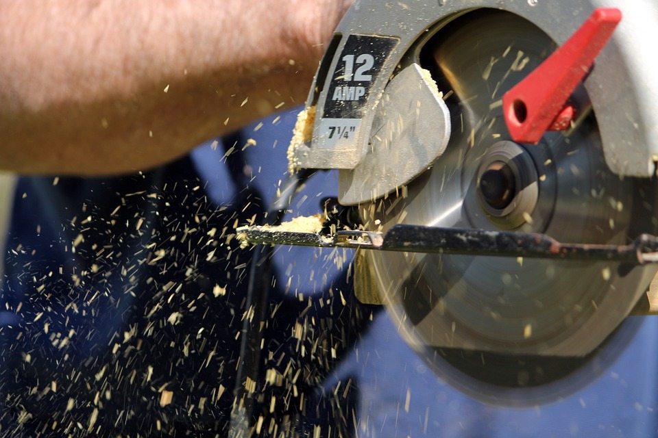 A track saw blade with saw dust flying off it