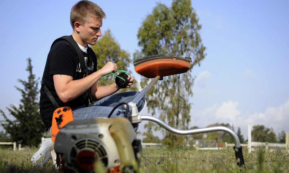 a man replacing line trimmer spool