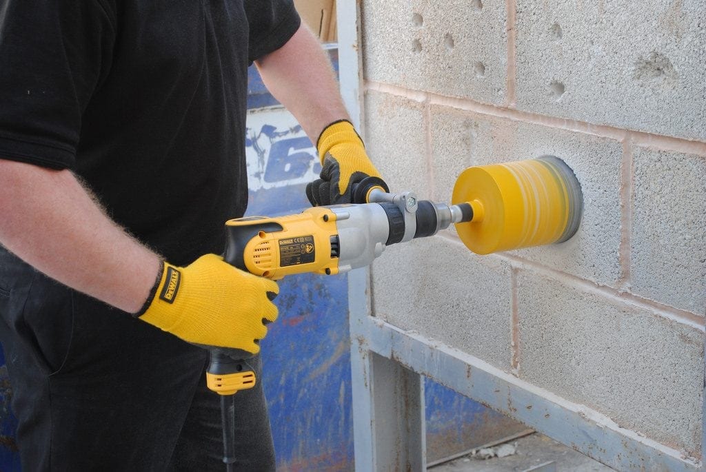 A Dewalt Drill drilling into a wall