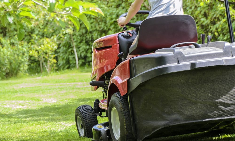 someone riding a lawn mower over grass