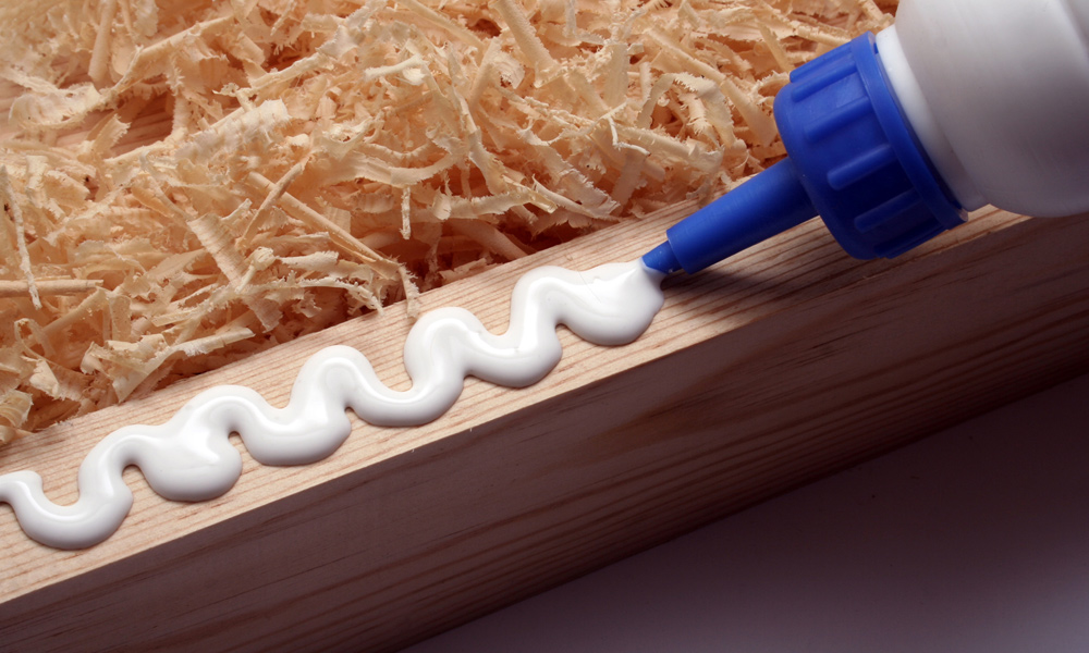 glue nozzle applying glue to wood