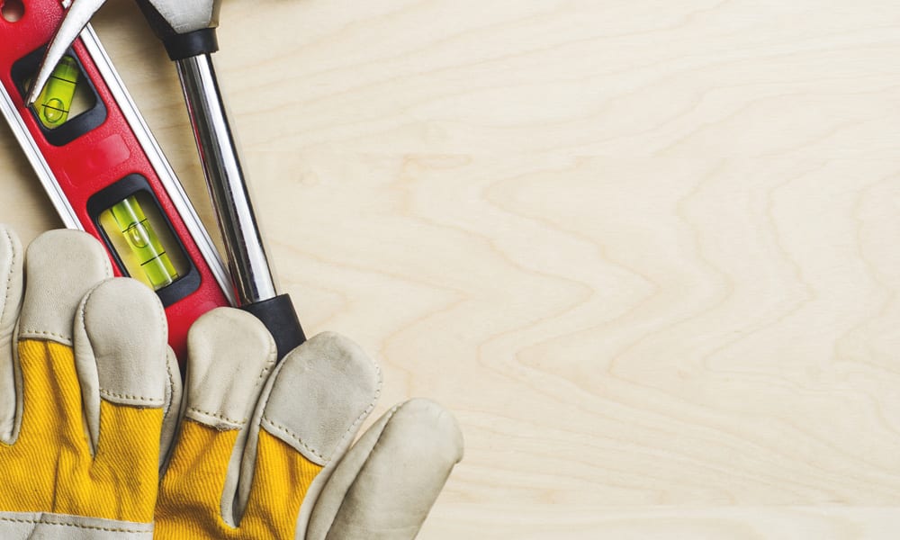 work gloves on a table with other tools next to them 