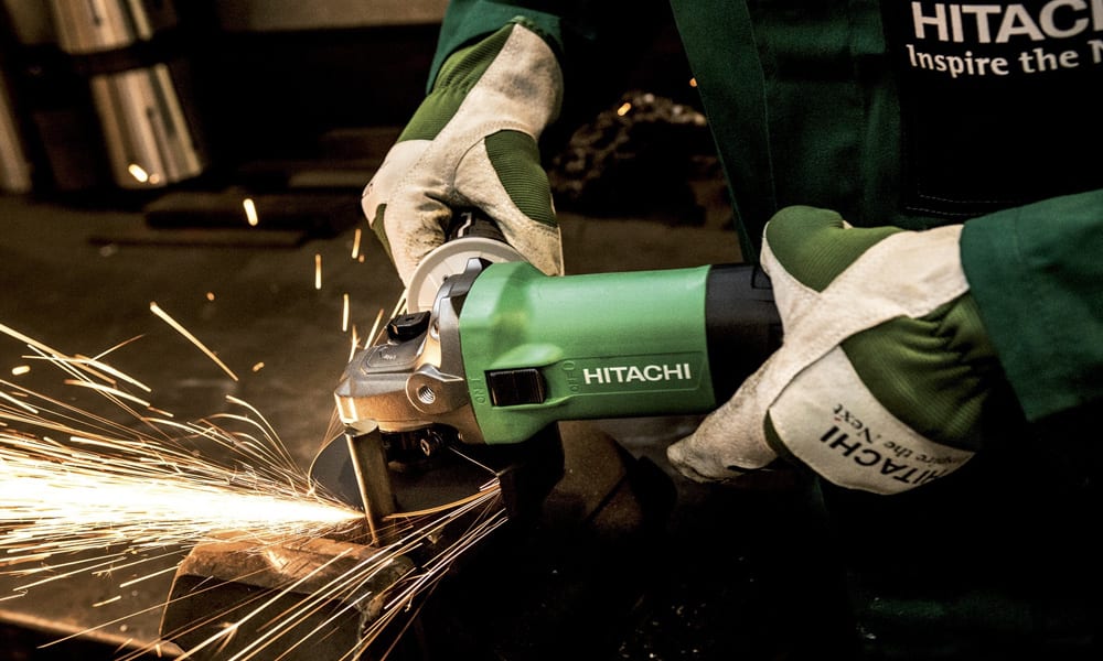 A workman using a angle grinder wearing gloves